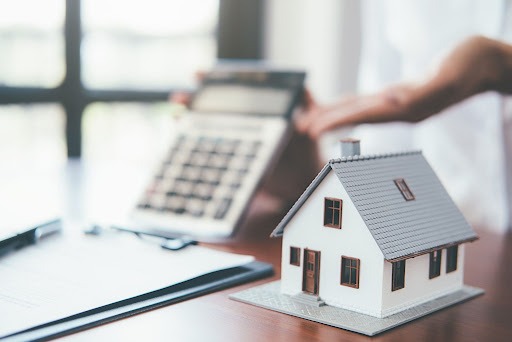 Imagem ilustrativa de uma casinha e calculadora, simulando a dúvida "construir ou comprar pronto 2021"